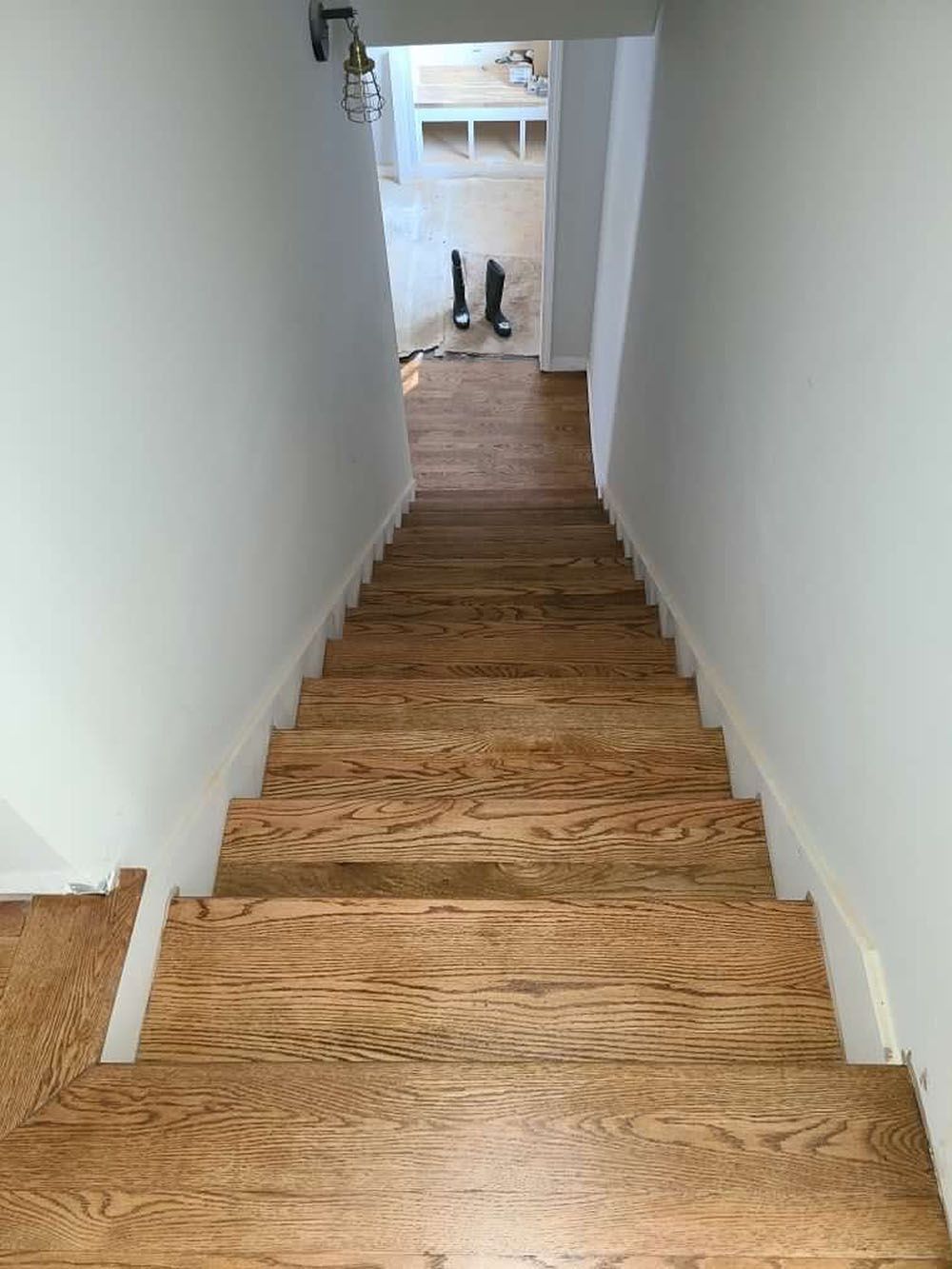 Stairs (After) - Staircase with worn carpet framed by white door and molding; doorway to room on right.