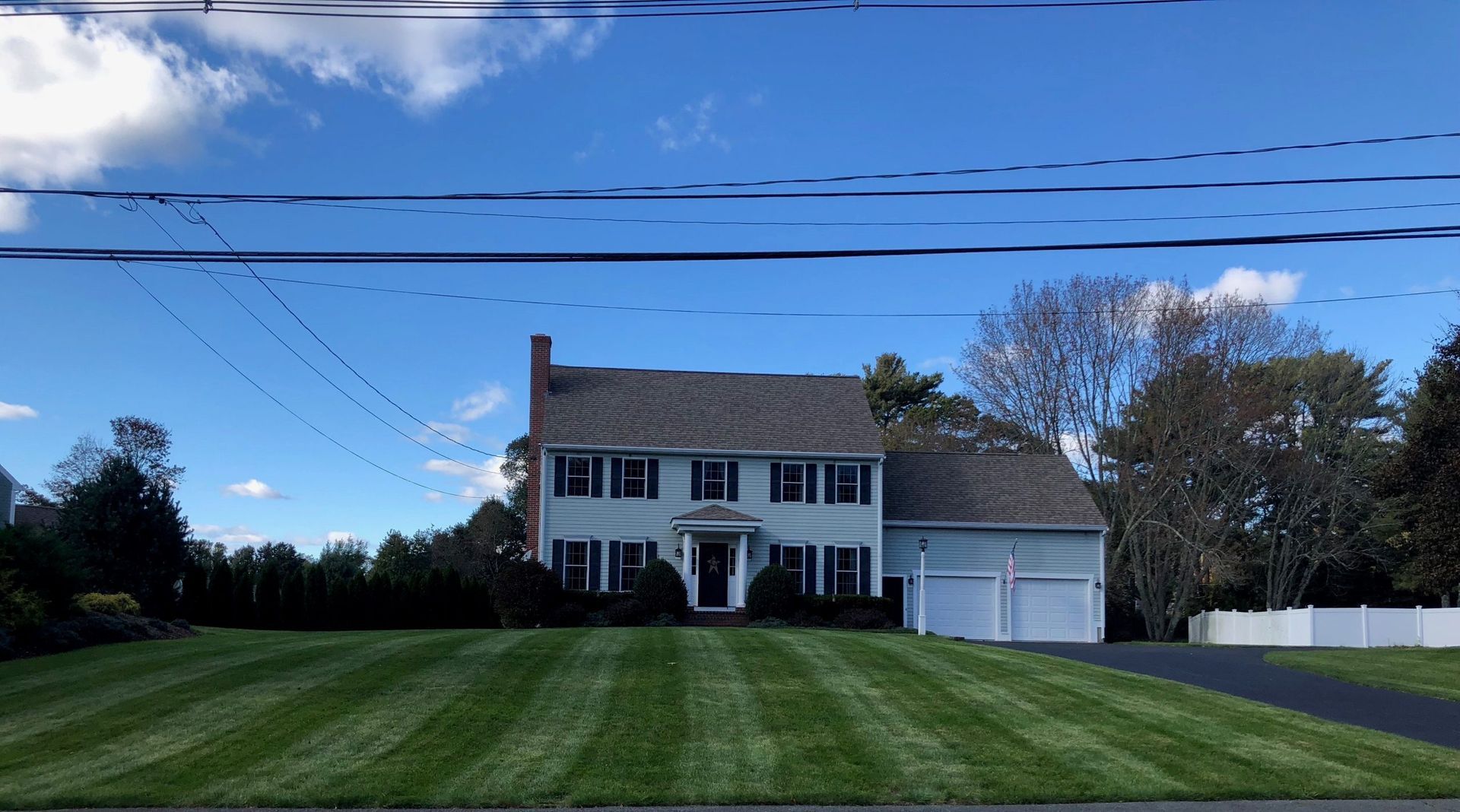 A large white house with a lush green lawn in front of it