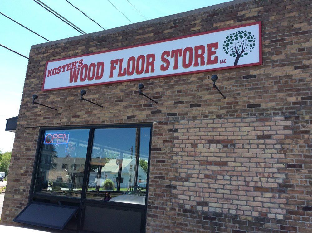 A brick building with a sign that says wood floor store