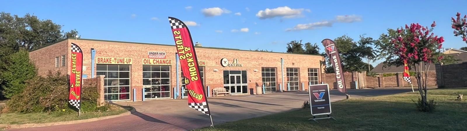 A large brick building with flags in front of it.