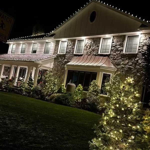 House decorated with white Christmas lights at night.