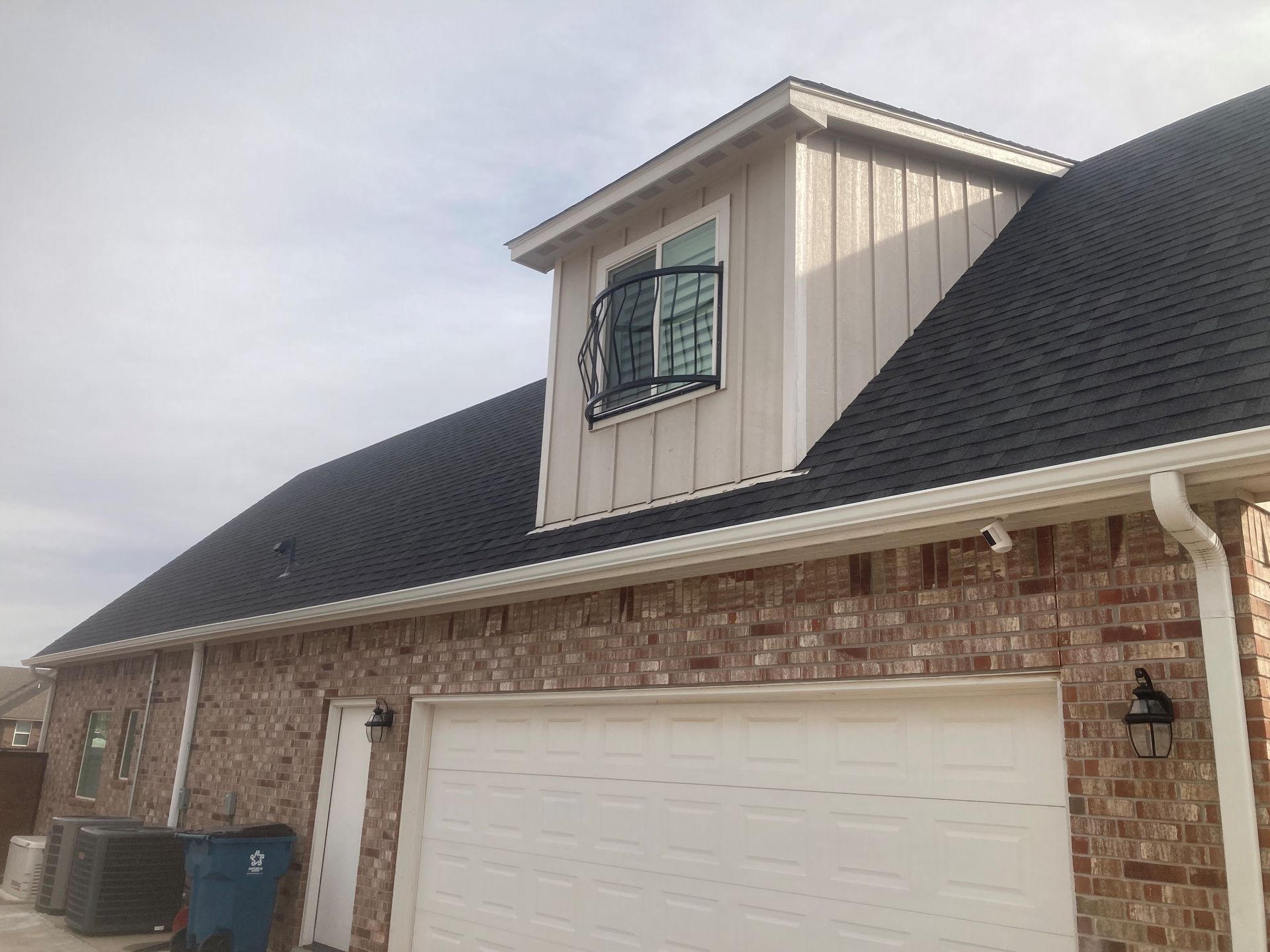 A house with a garage and a window on the roof.