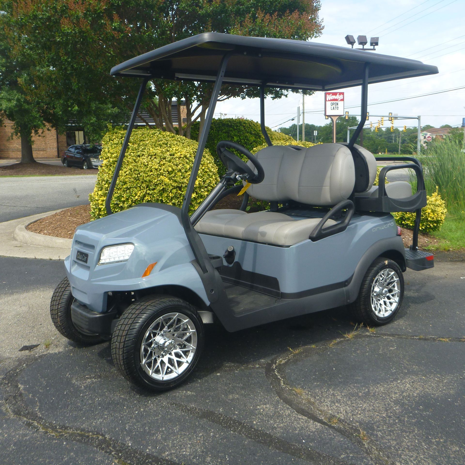 A blue xps golf cart is parked in a parking lot