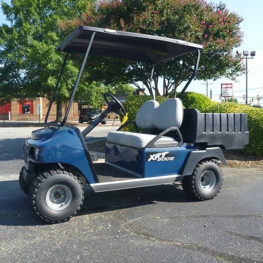 A blue xps golf cart is parked in a parking lot