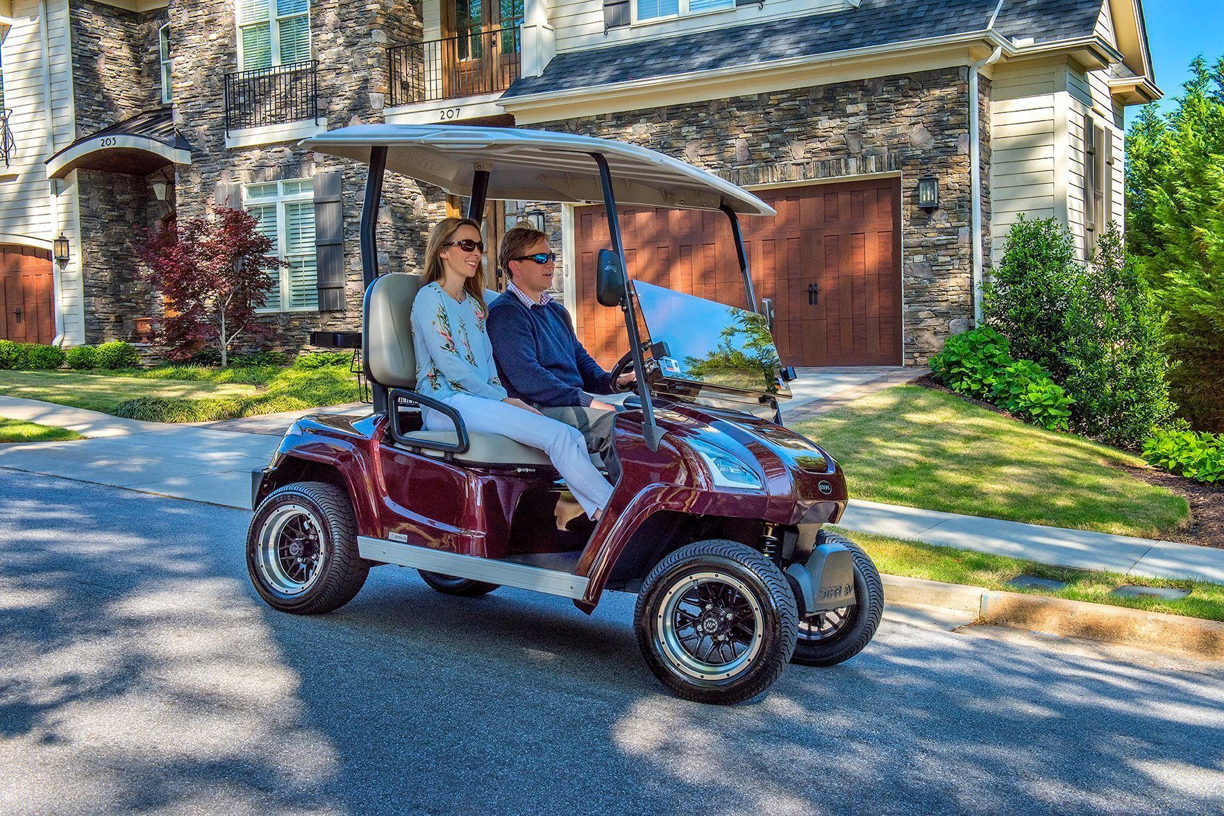 A white golf cart with two seats on a white background.