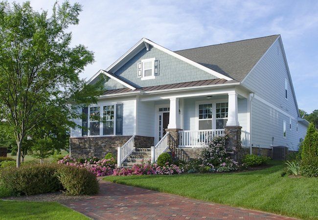 a large white house with a brick driveway in front of it