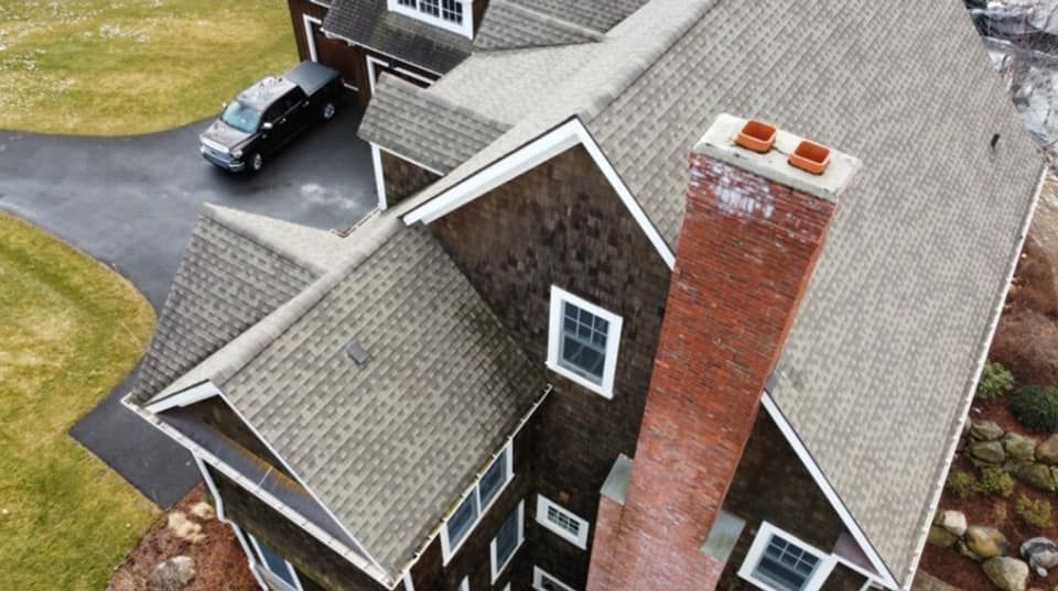 an aerial view of a large house with a car parked in the driveway .