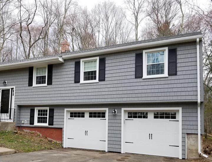 a screened in porch with a lot of windows on the side of a house .