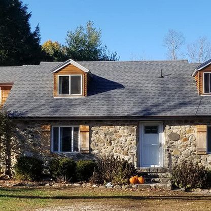 a stone house with two pumpkins in front of it