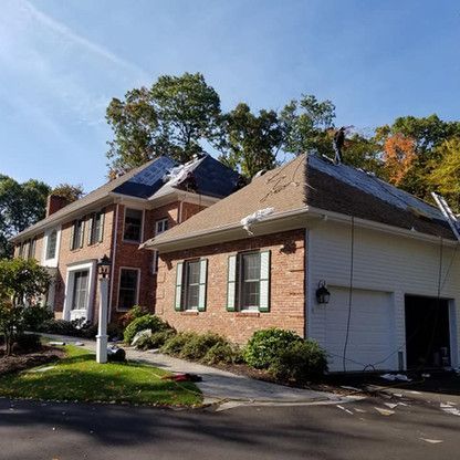 a man is working on the roof of a house .