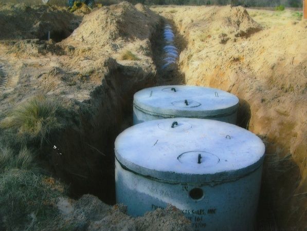 Two concrete septic tanks are sitting in the dirt