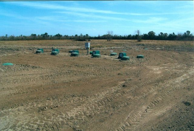 A dirt field with a blue sky in the background