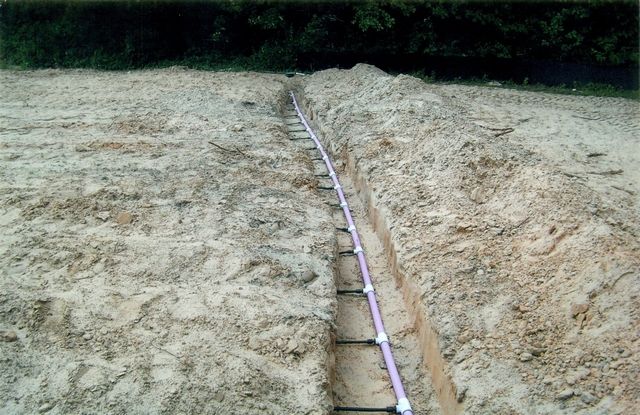 A ladder is sitting in the middle of a dirt field.