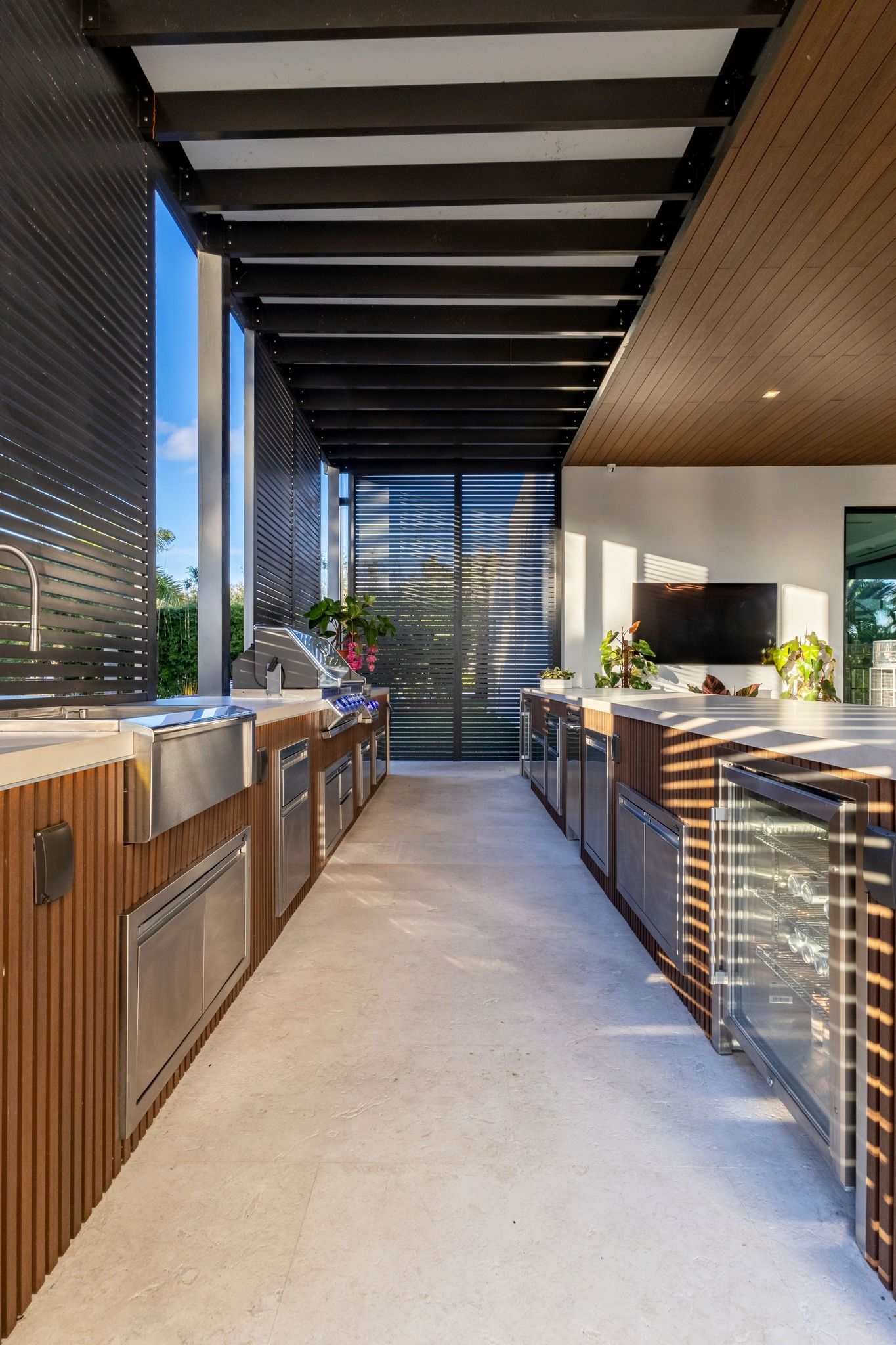 A long hallway leading to a kitchen with stainless steel appliances
