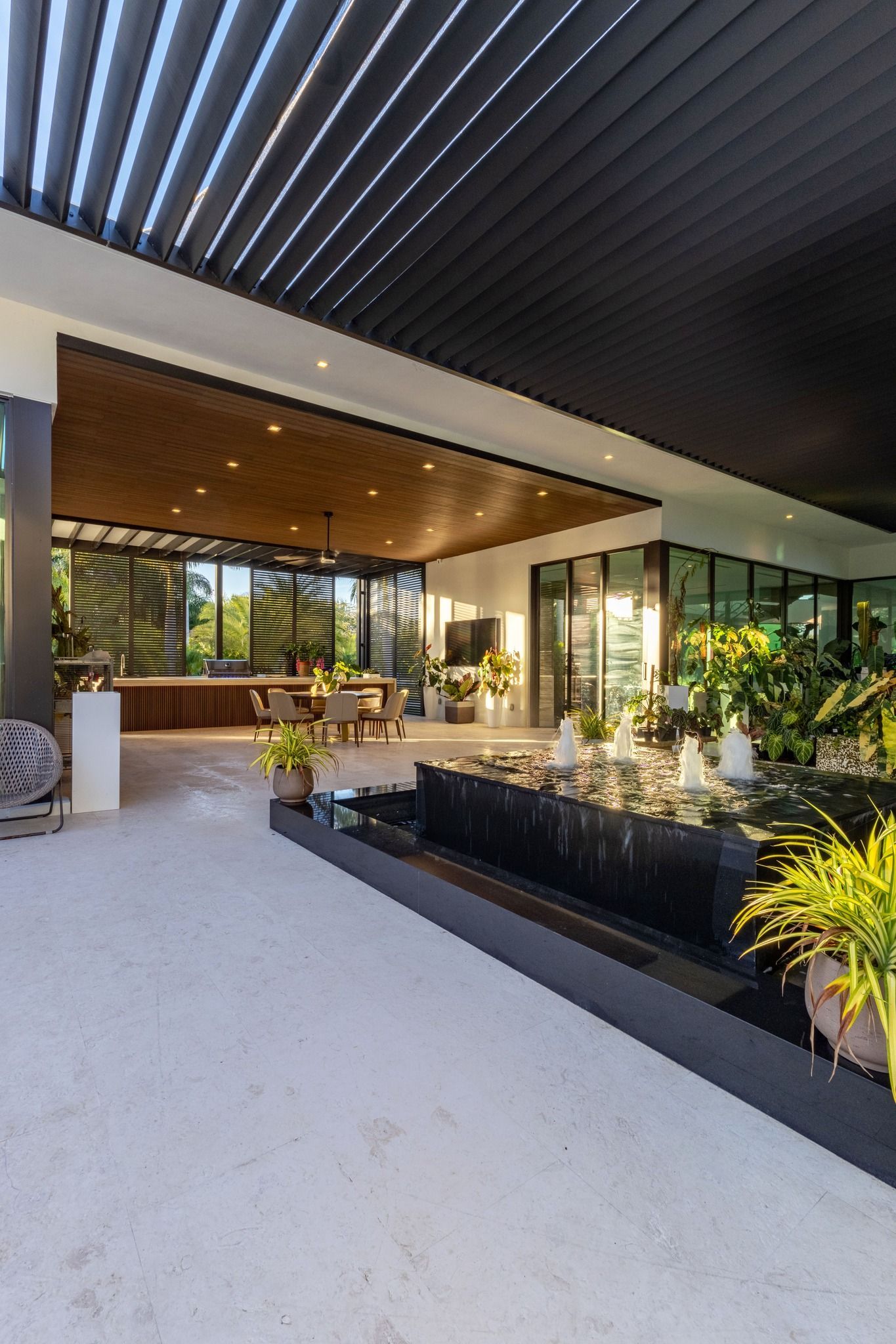 A large room with a lot of windows and a fountain in the middle of it.