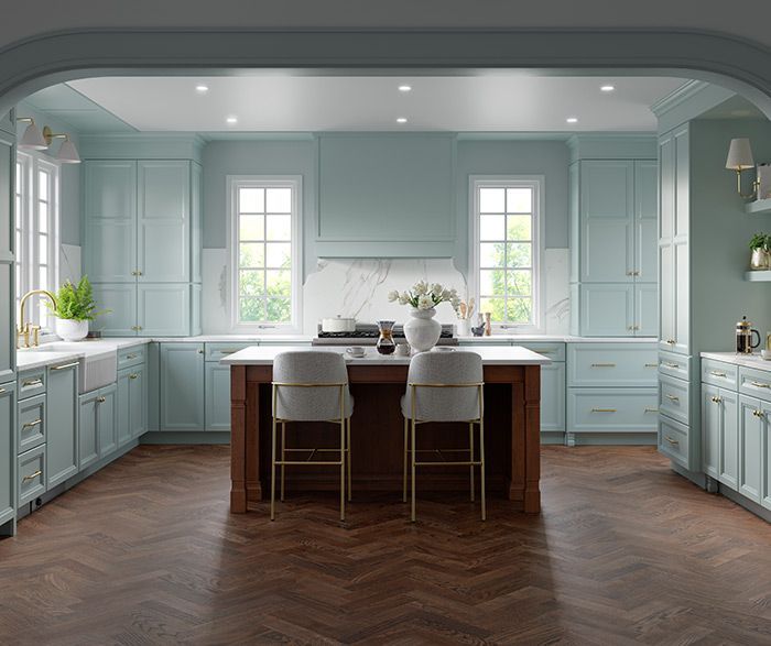 Spacious kitchen with blue cabinets, a dark wood island, and two bar stools, on a herringbone floor.