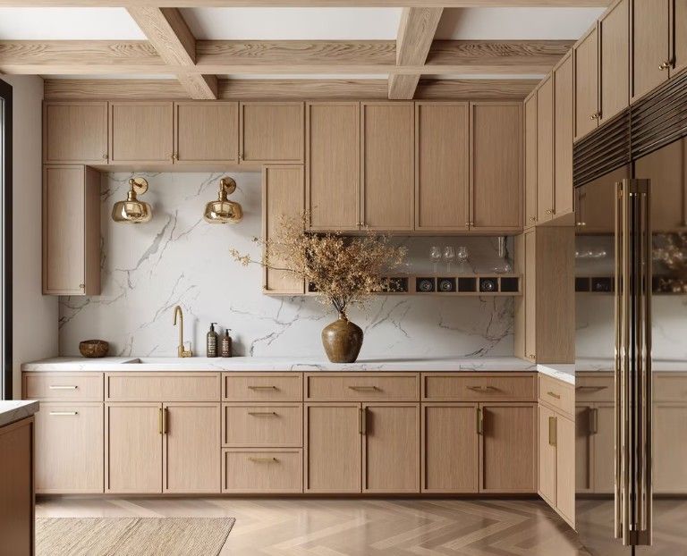 Wooden kitchen with light cabinets, marble backsplash, and gold fixtures.