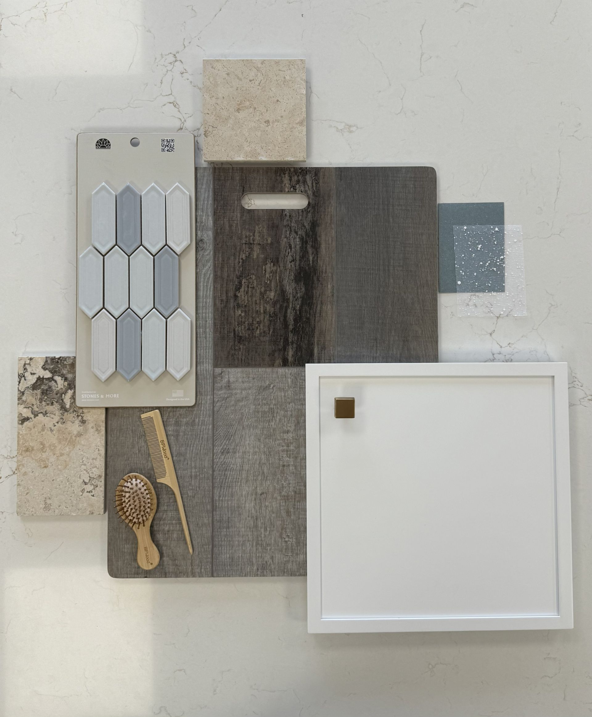 A flat-lay interior design mood board featuring grey tile samples, wood grain flooring, stone textures, and white board.