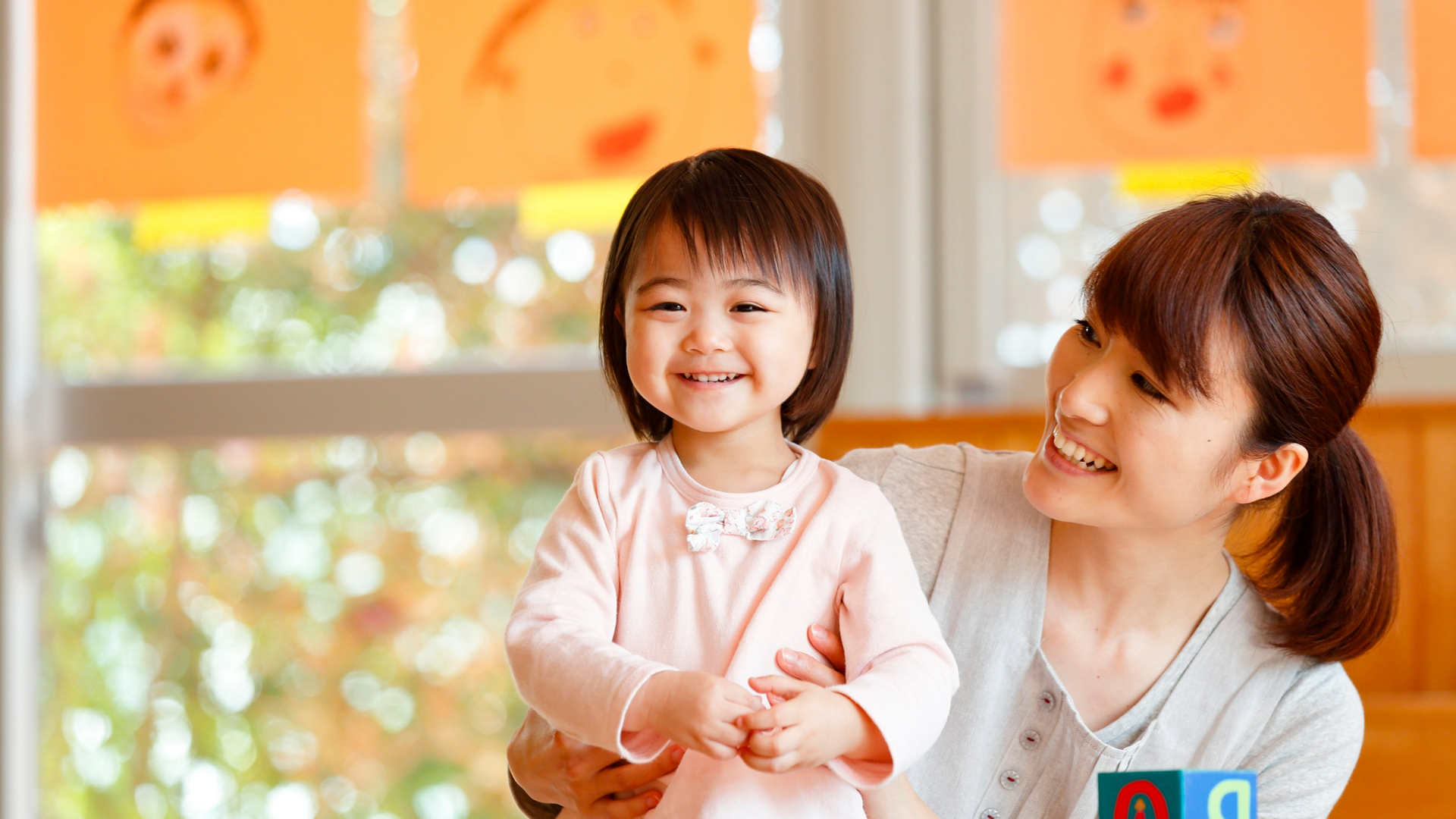 Parent caregiver smiling and playing with child in a safe pediatric medical bed environment