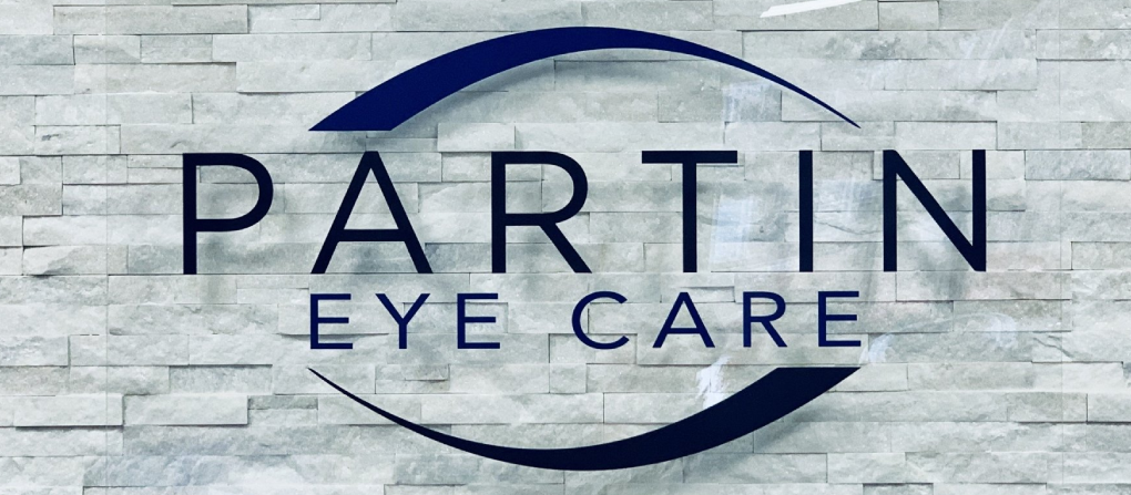 Partin Eye Care logo on a light stone background with dark blue text and oval graphic