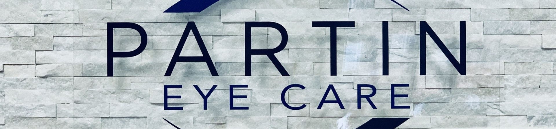 Partin Eye Care logo on a light stone background with dark blue text and oval graphic