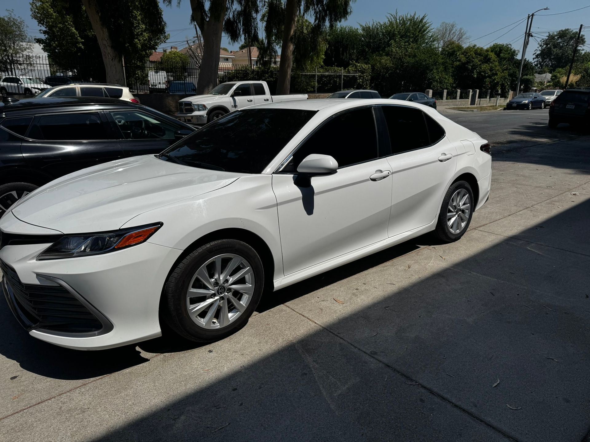 White Toyota Camry parked outdoors with tinted windows.