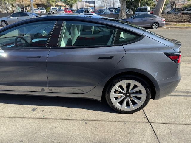 Gray Tesla Model 3 sedan parked on a city street.
