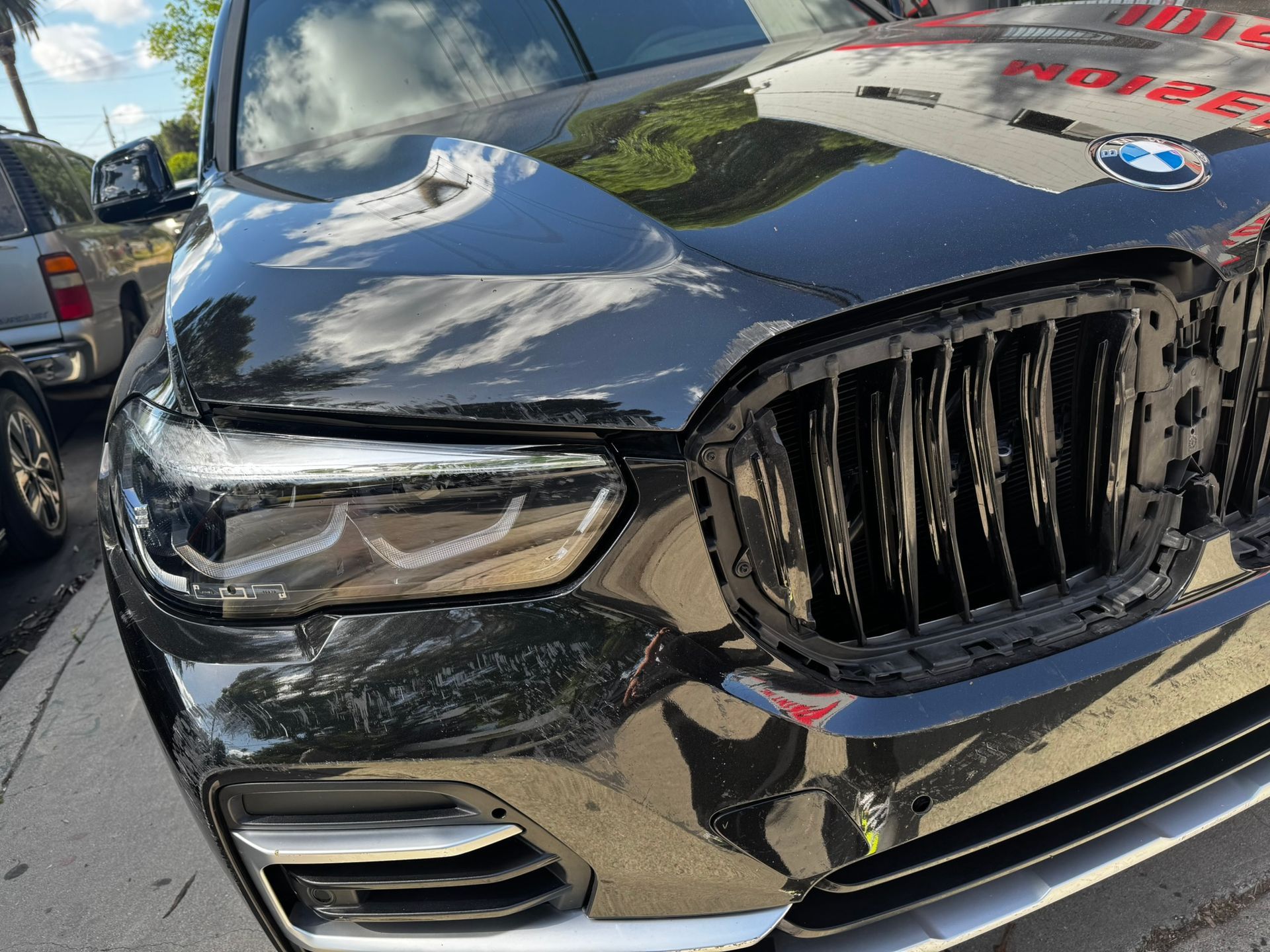 Black BMW car front with the grill and headlight visible.