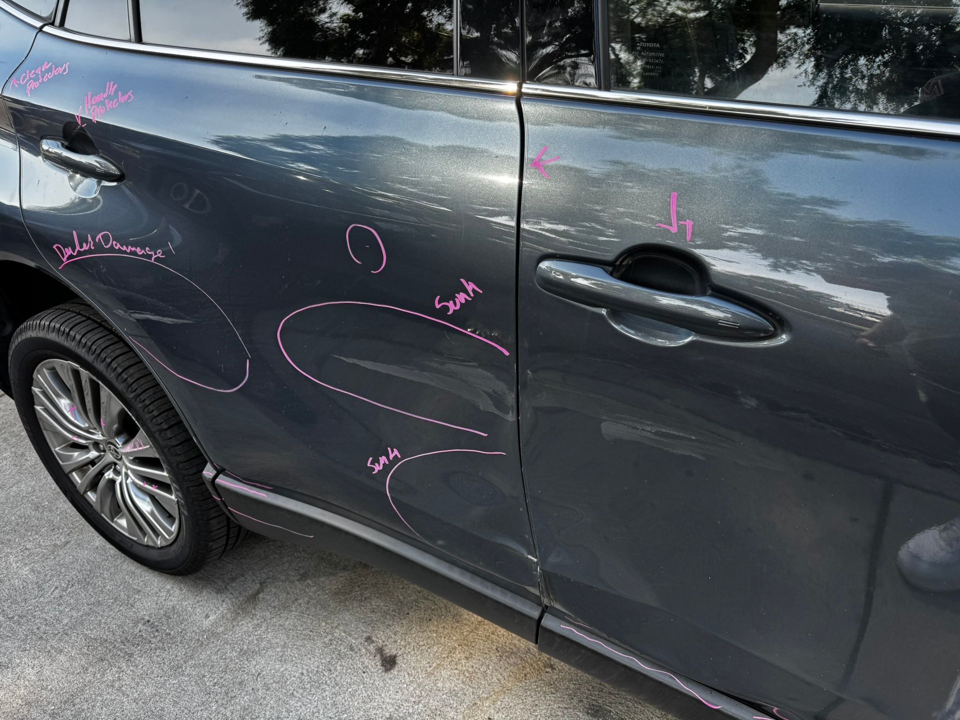 A gray car with pink markings indicating damage on the side door.