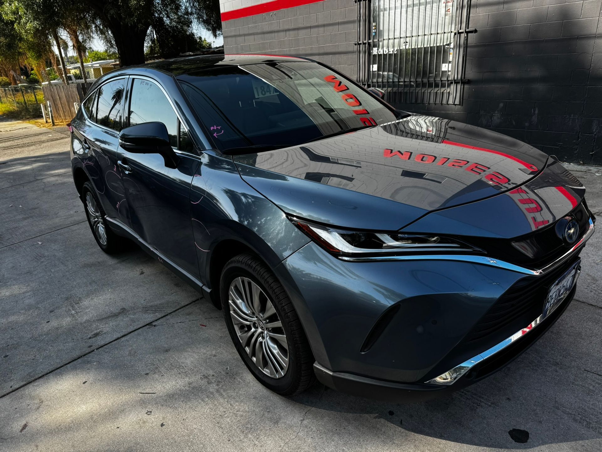 Gray Toyota Venza parked on a concrete surface, in front of a building.