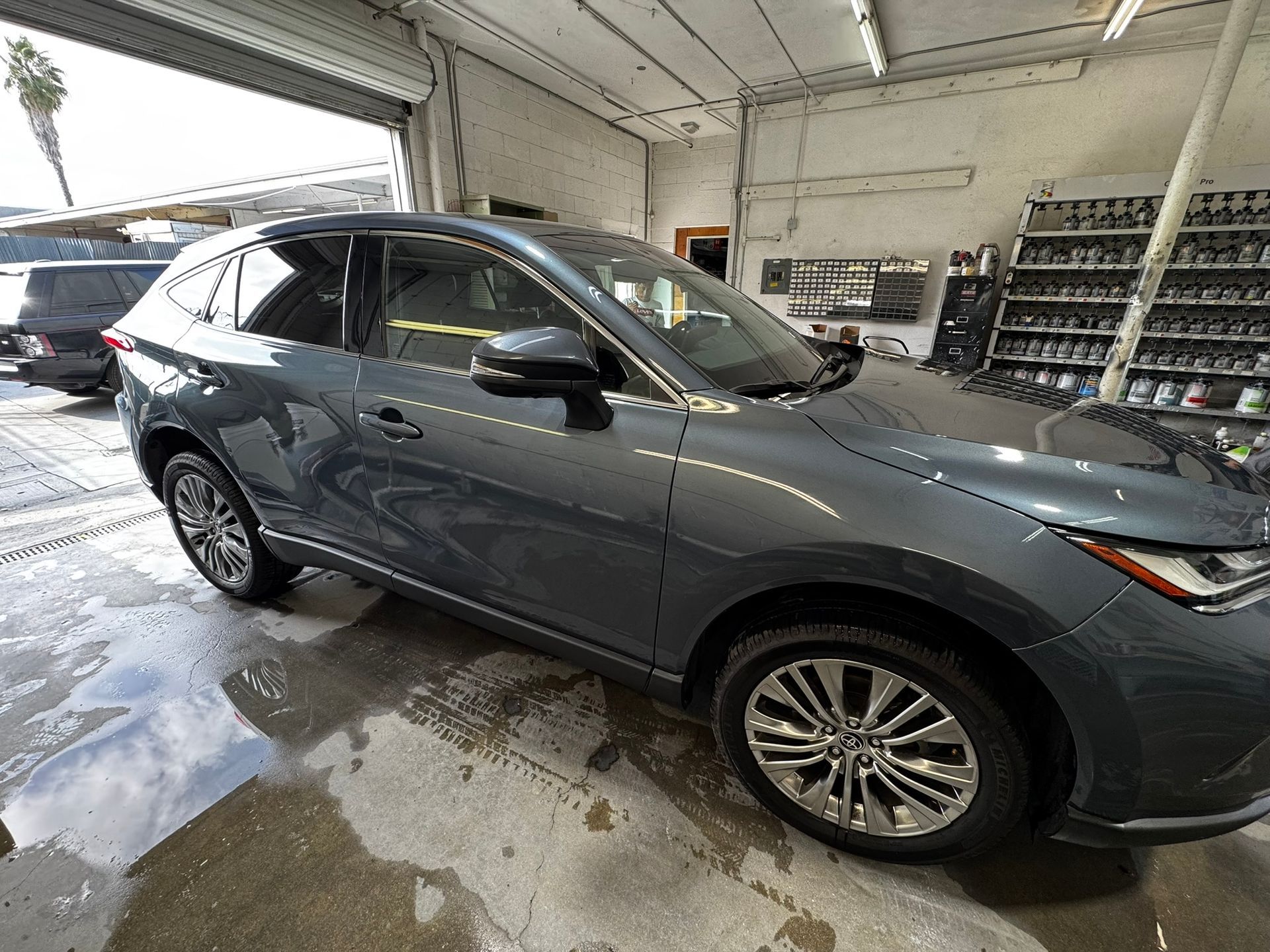 Gray SUV parked in a garage with chrome wheels.