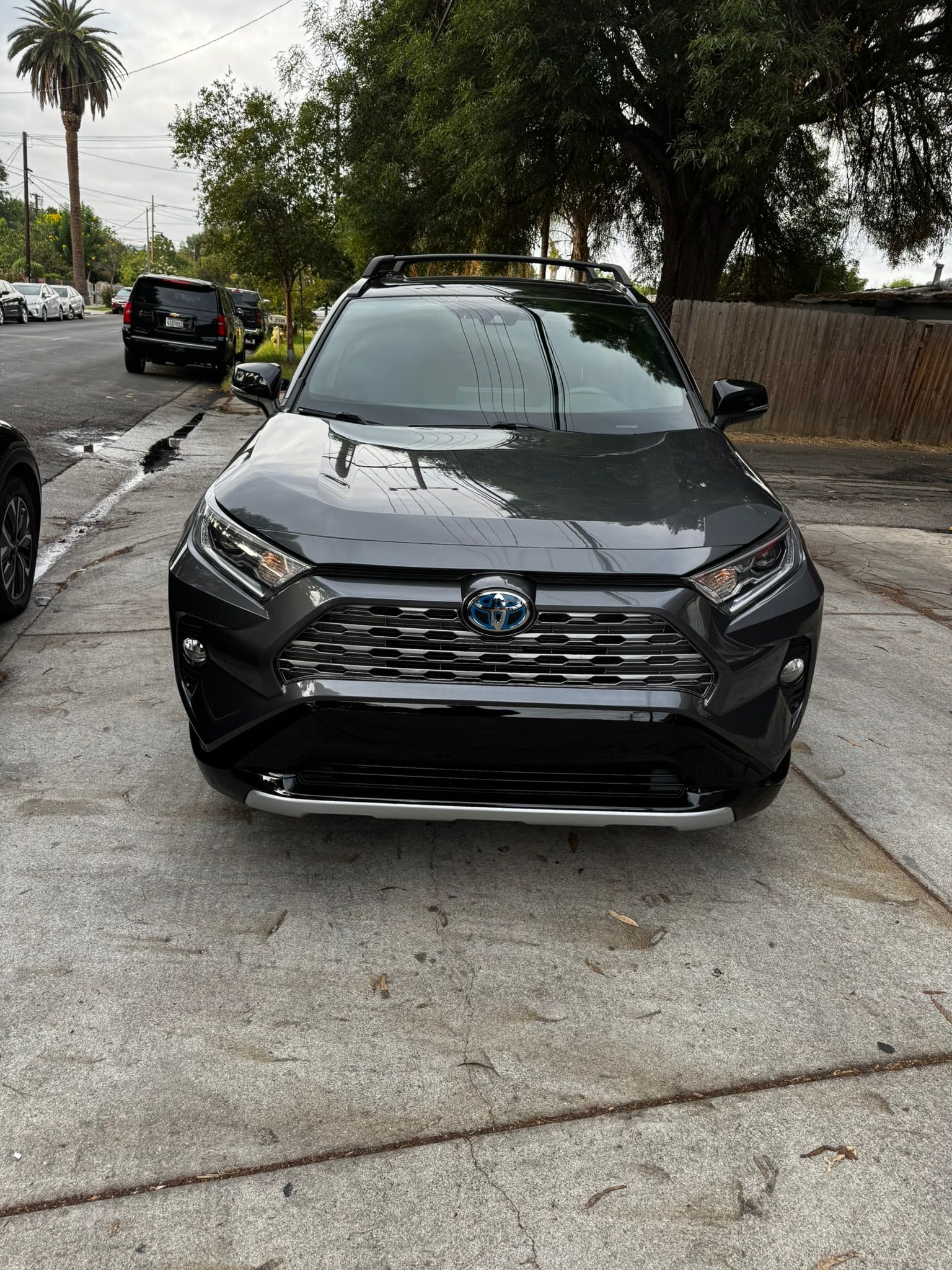 Dark gray Toyota RAV4 Hybrid parked on a sidewalk.