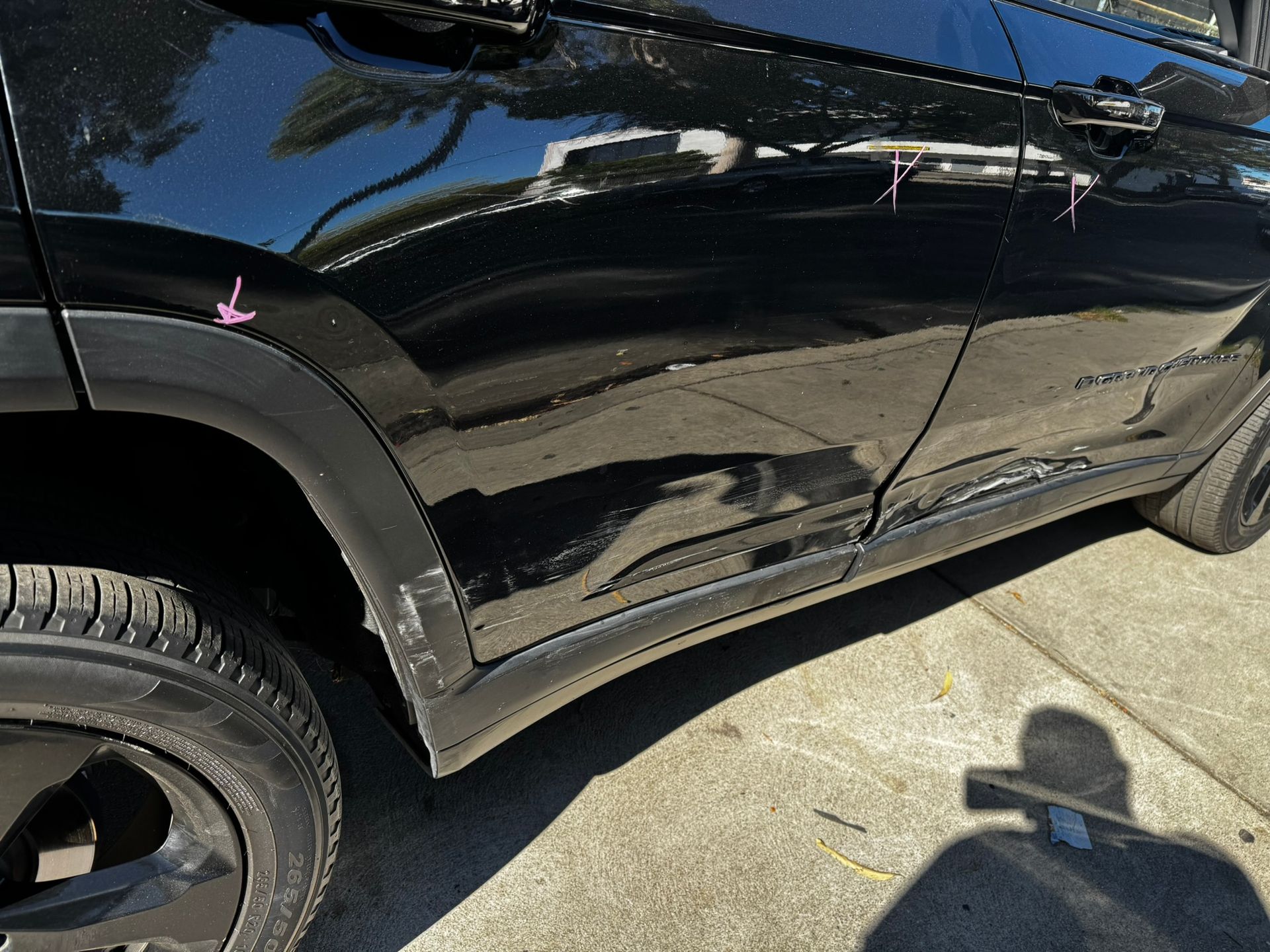 Black SUV with significant damage along the side panels, showing dents and scraped paint.
