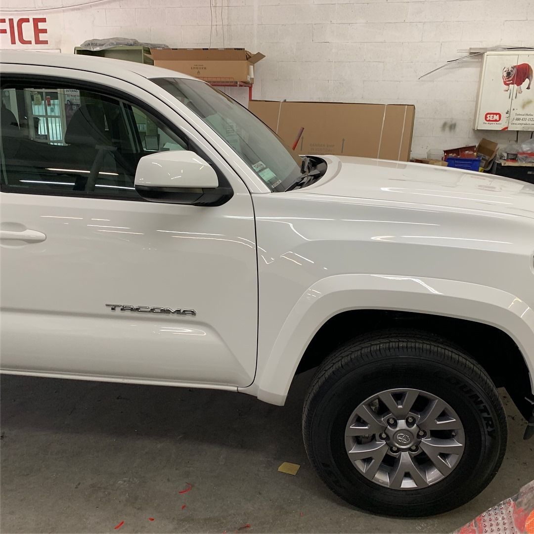 White Toyota Tacoma truck in a garage setting.