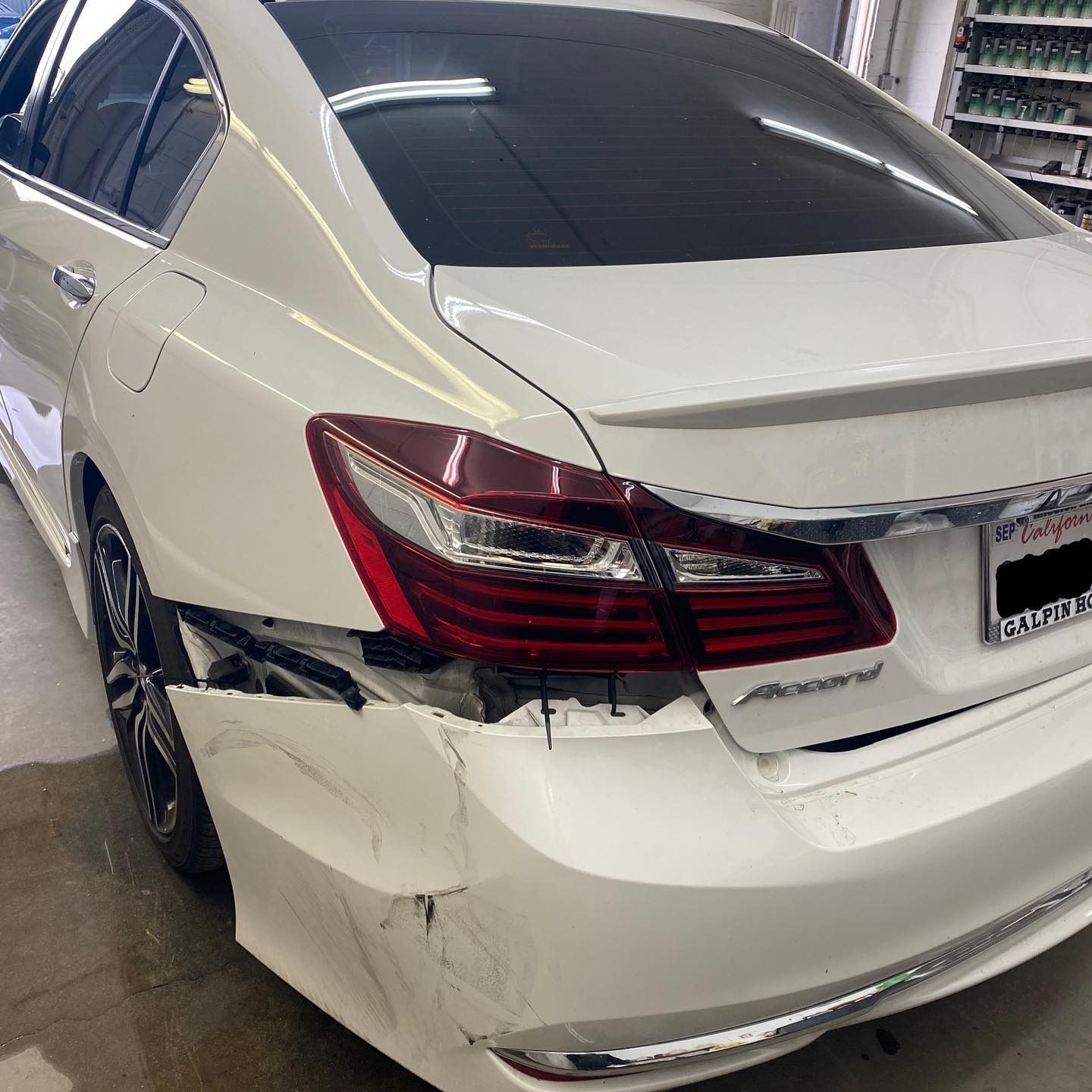 White Honda Accord with significant damage to the rear bumper and quarter panel.
