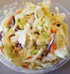 Coleslaw in a clear bowl, creamy white dressing, shredded cabbage, and carrots