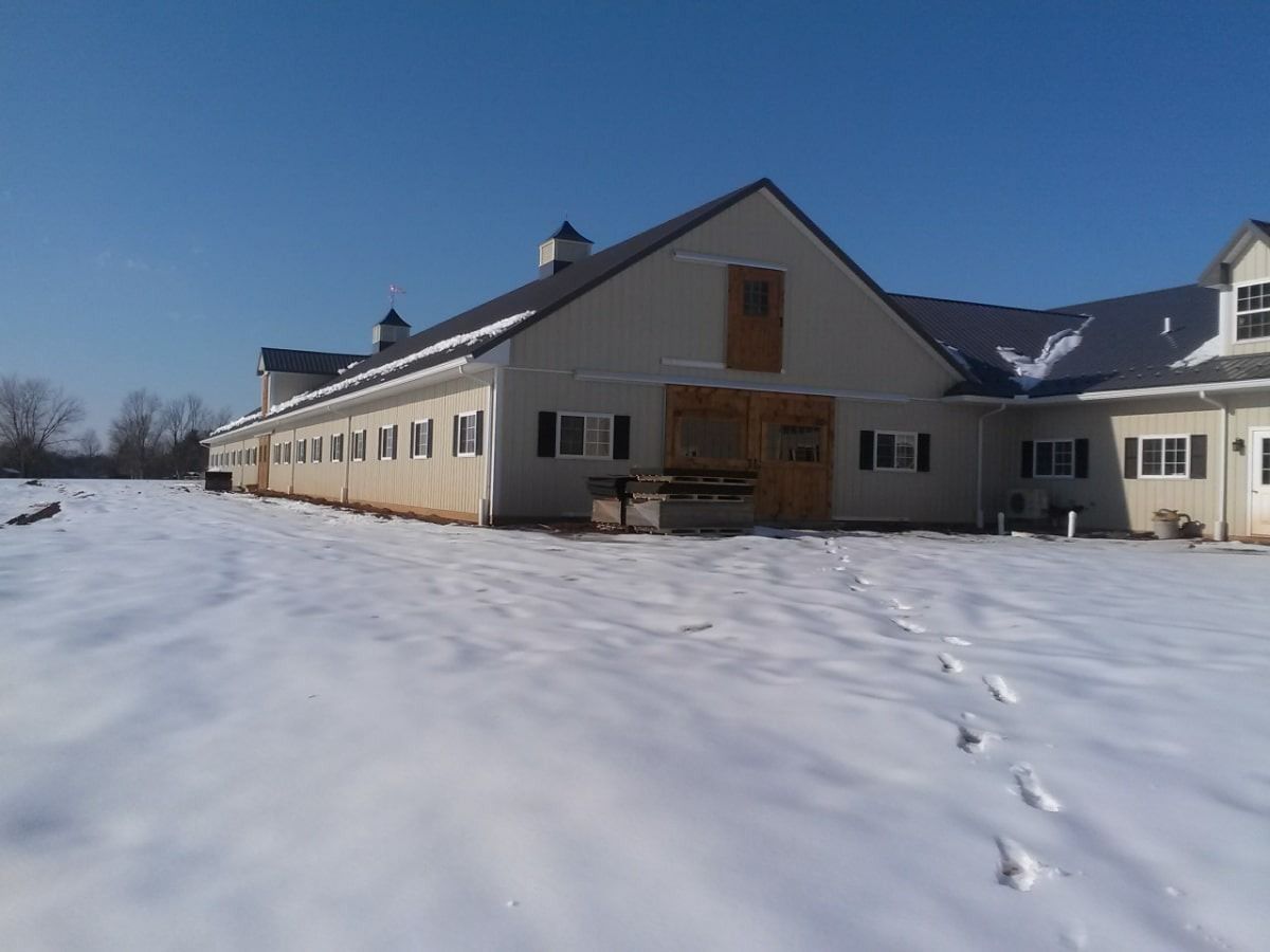Snow-covered building with footprints leading to the entrance under a clear blue sky