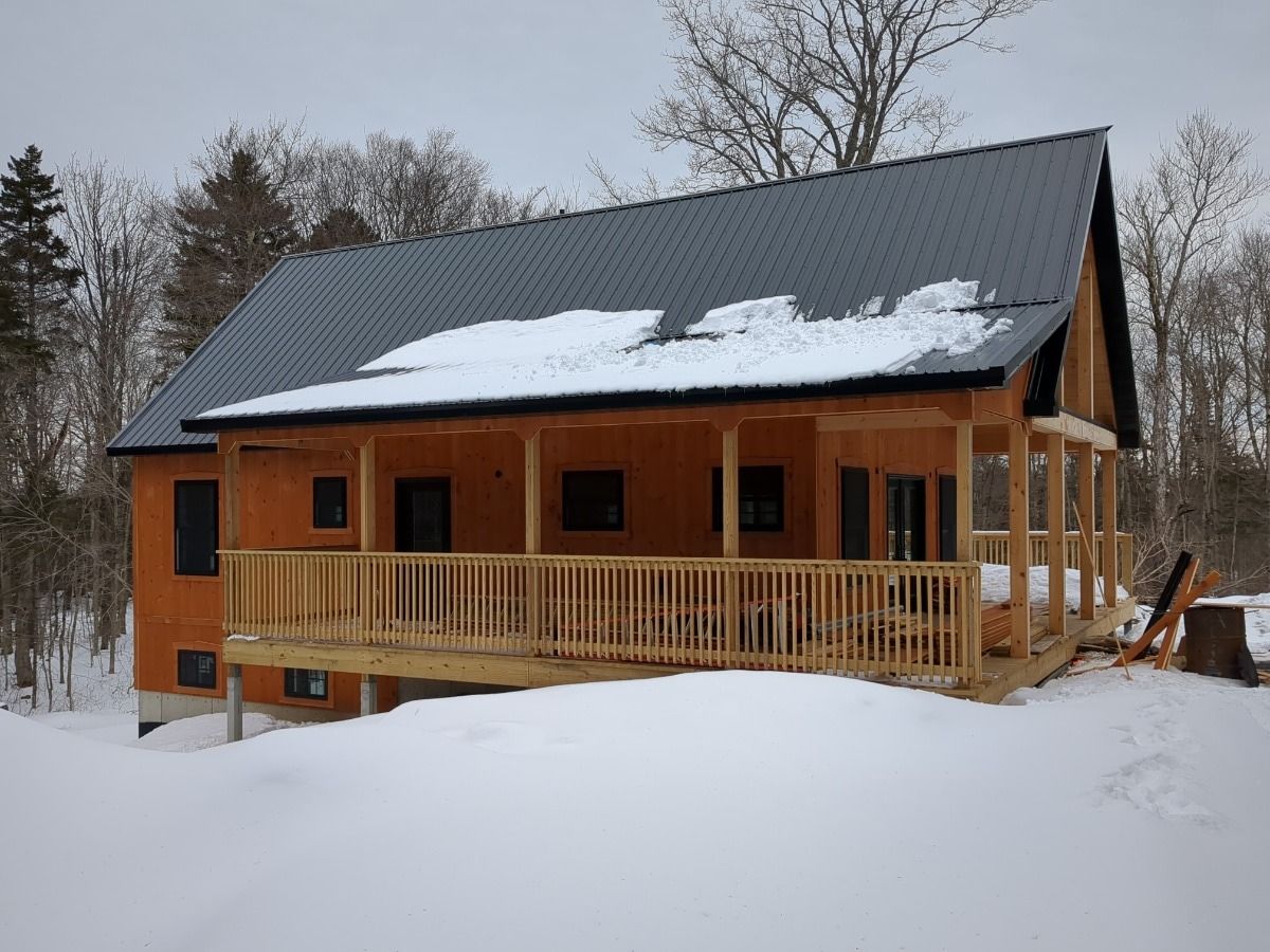 Wooden cabin with snow-covered roof in a snowy forest clearing