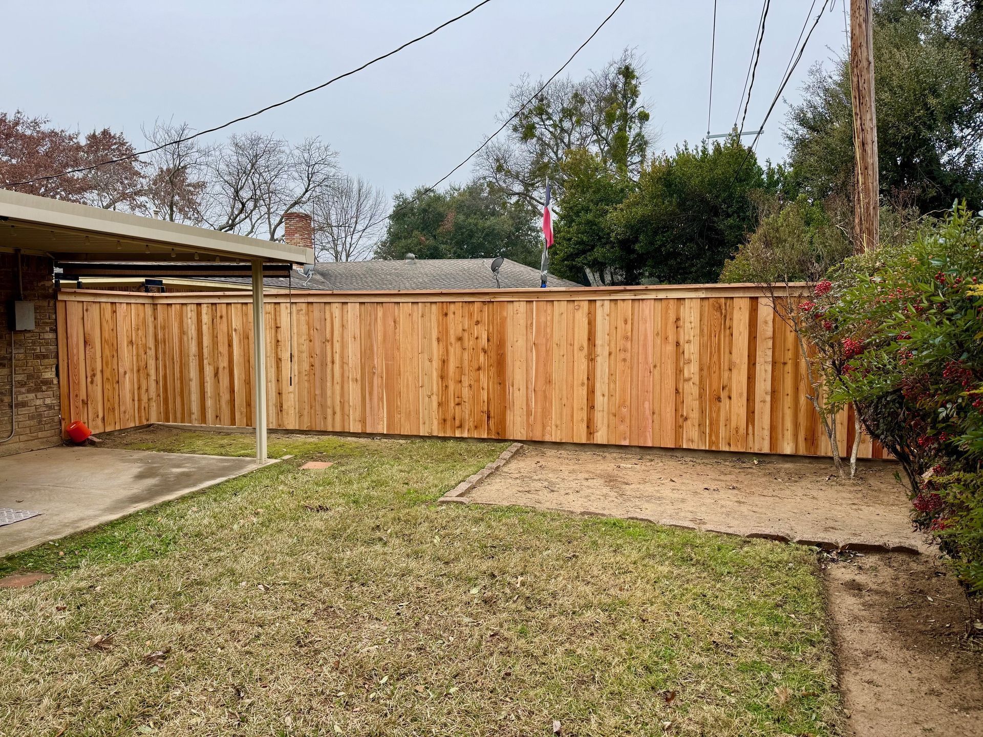 A wooden fence is in the backyard of a house.