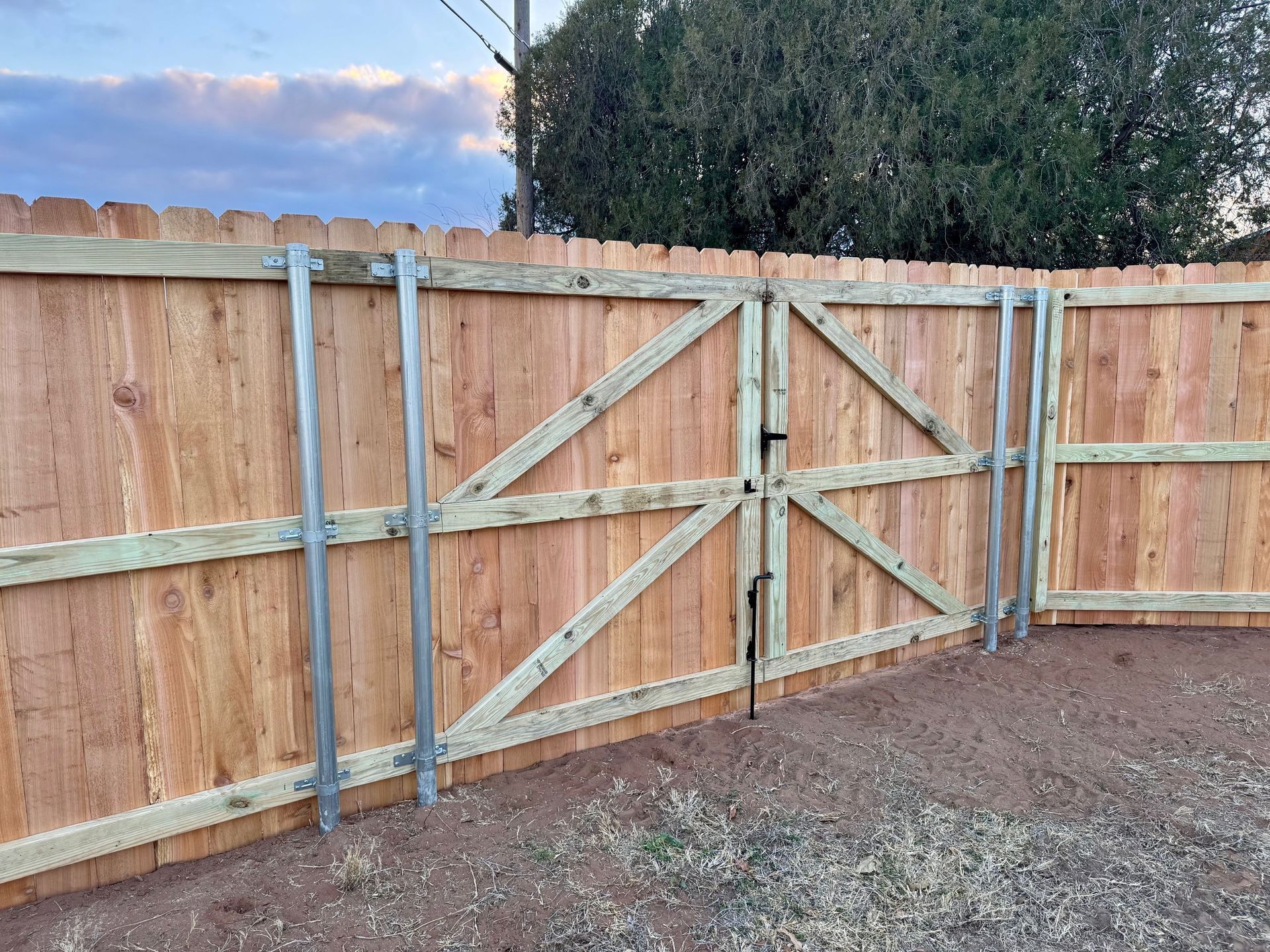 A wooden fence with a gate attached to it.