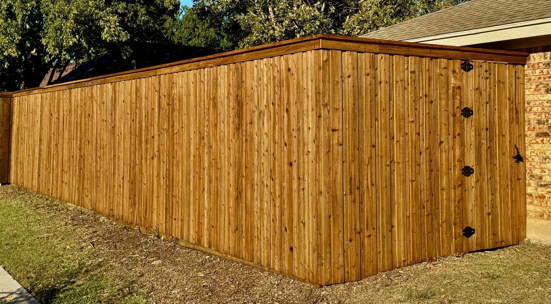 A wooden fence is sitting in front of a house.