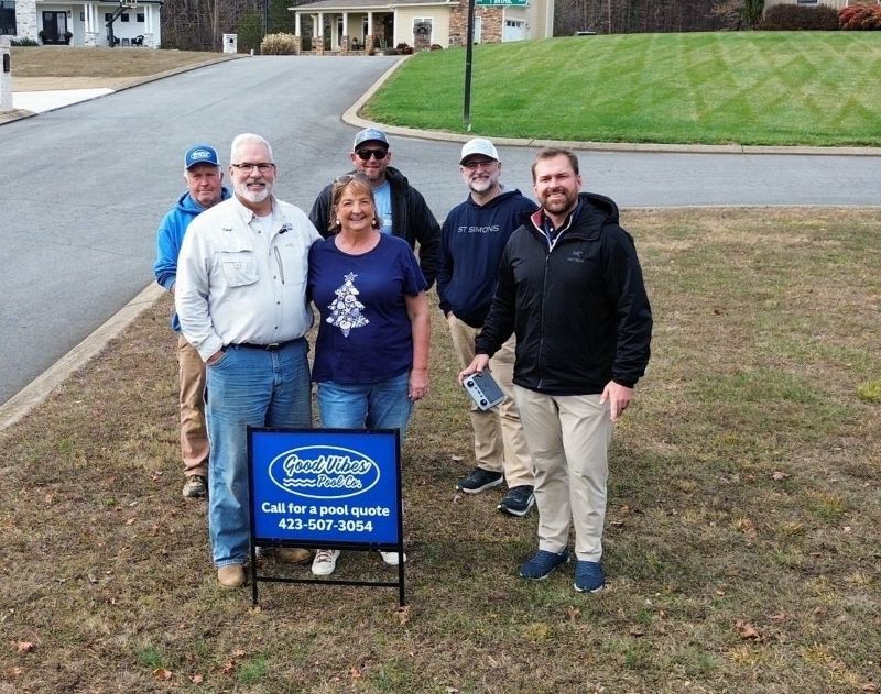 A group of people are standing in front of a sign that says ' a ' on it