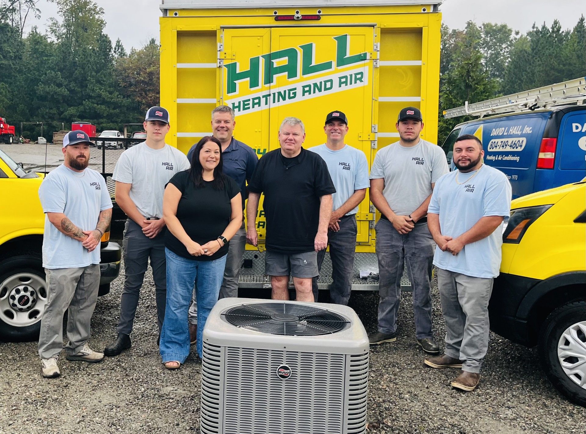 Group of people posing with a yellow truck that says 
