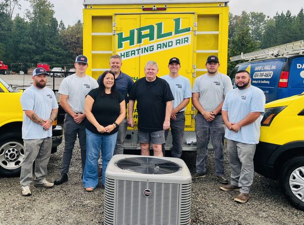Group of people posing with a yellow truck that says