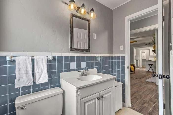 A bathroom with a sink , toilet and mirror.