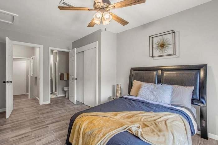 A bedroom with a large bed and a ceiling fan.