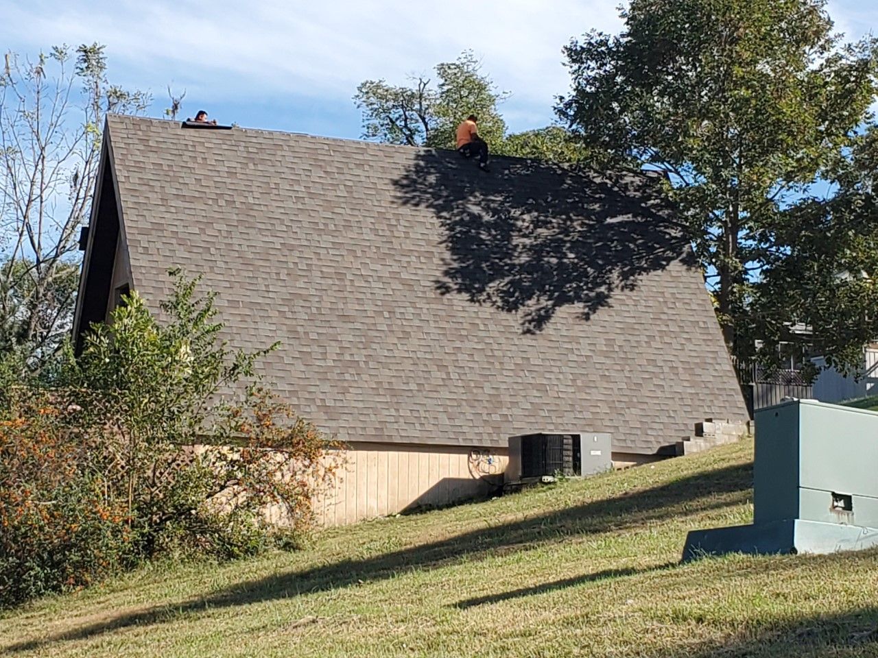 A man is working on the roof of a house.