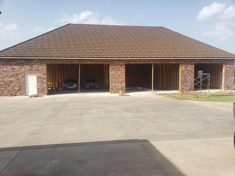 A large brick building with a garage under construction.