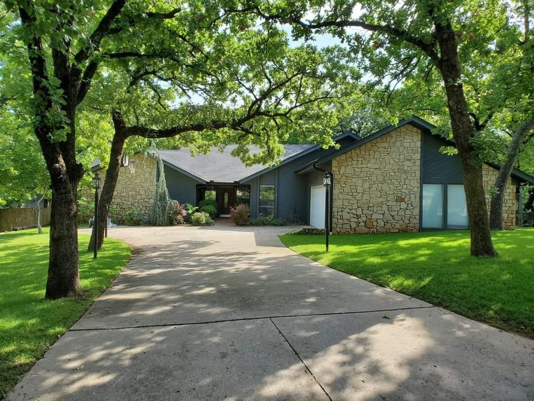 A driveway leading to a house surrounded by trees