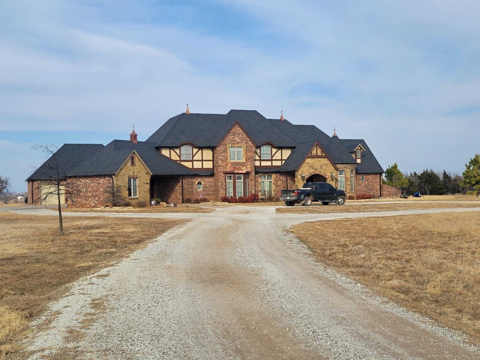 A large brick house with a black car parked in front of it.
